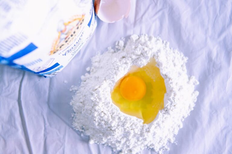 Eggs, flour, and fresh pasta on a kitchen surface