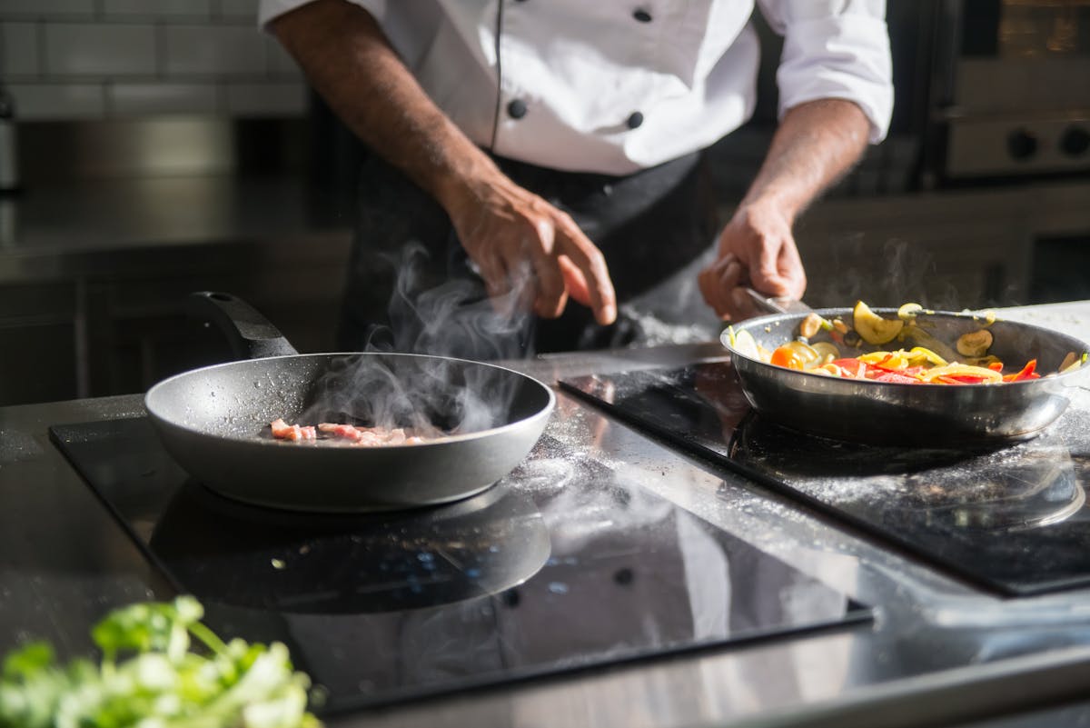 Solo traveler preparing pasta in a sunlit kitchen