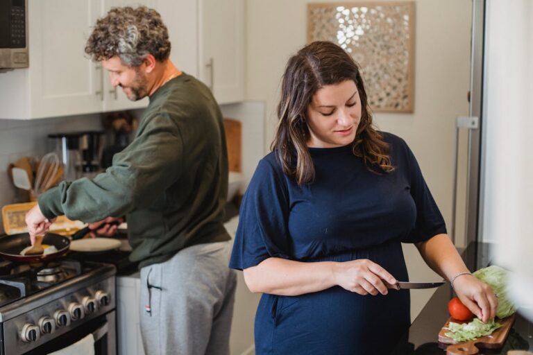 Cheerful couple cooking pasta together in the kitchen