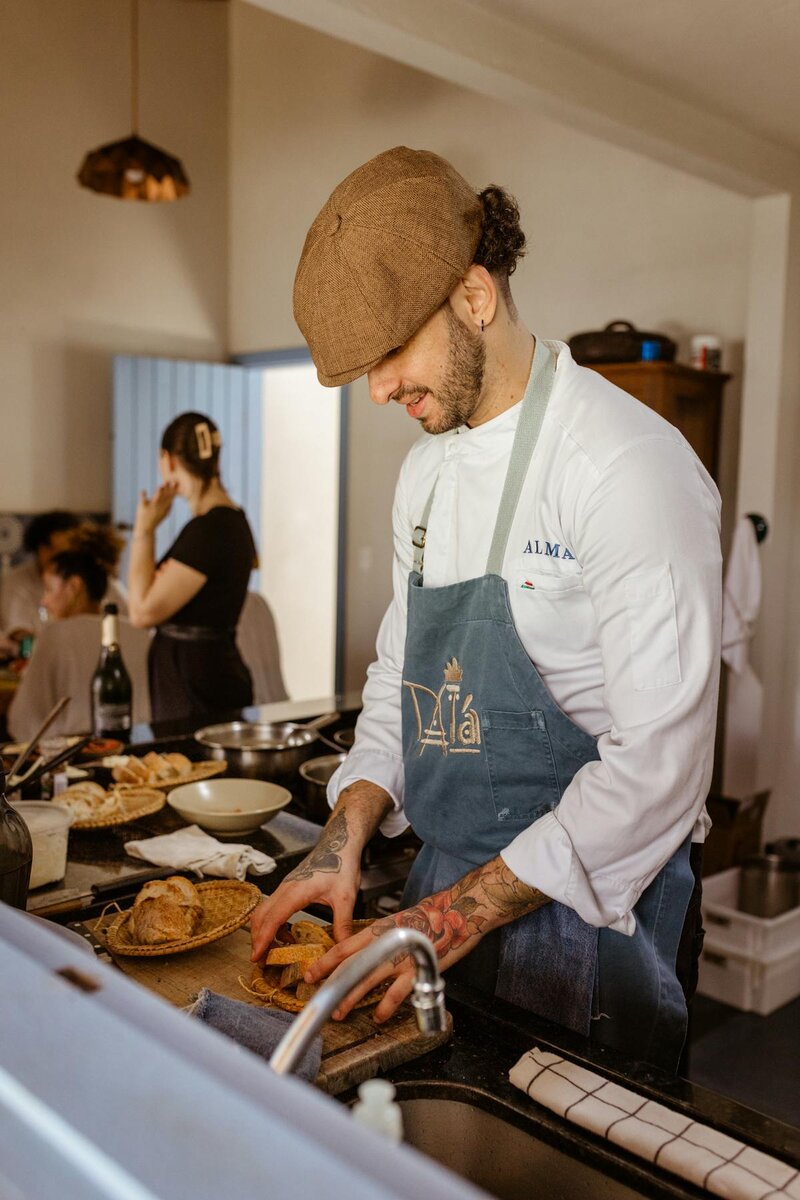 Smiling chef preparing fresh pasta in a cozy kitchen