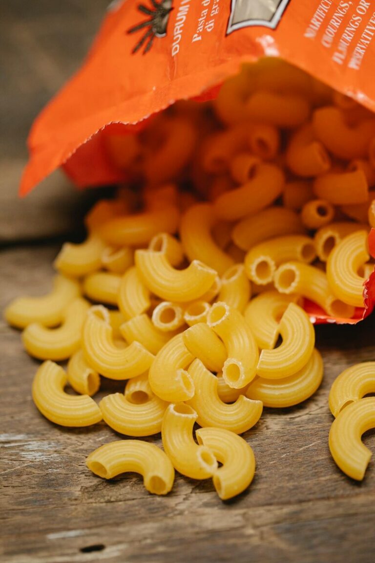 Raw fresh Italian pasta scattered across a wooden table