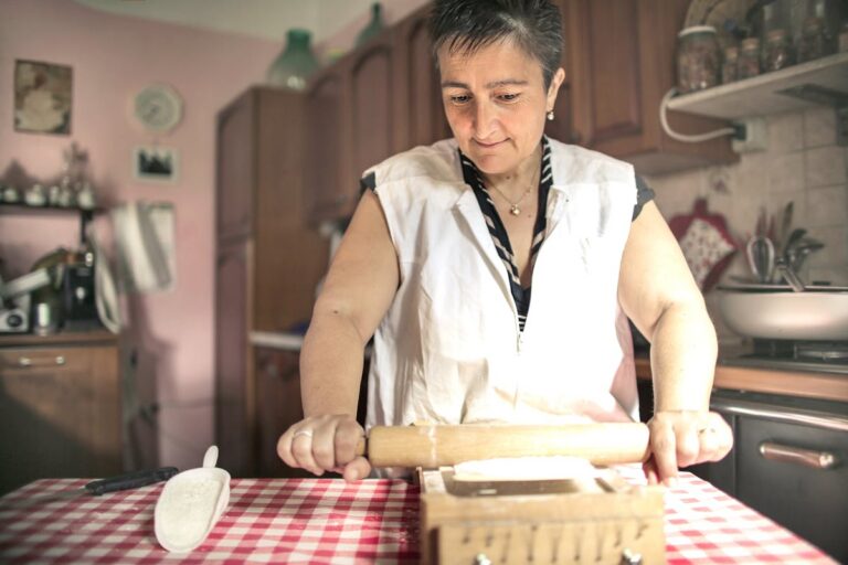Senior Italian woman rolling fresh pasta dough